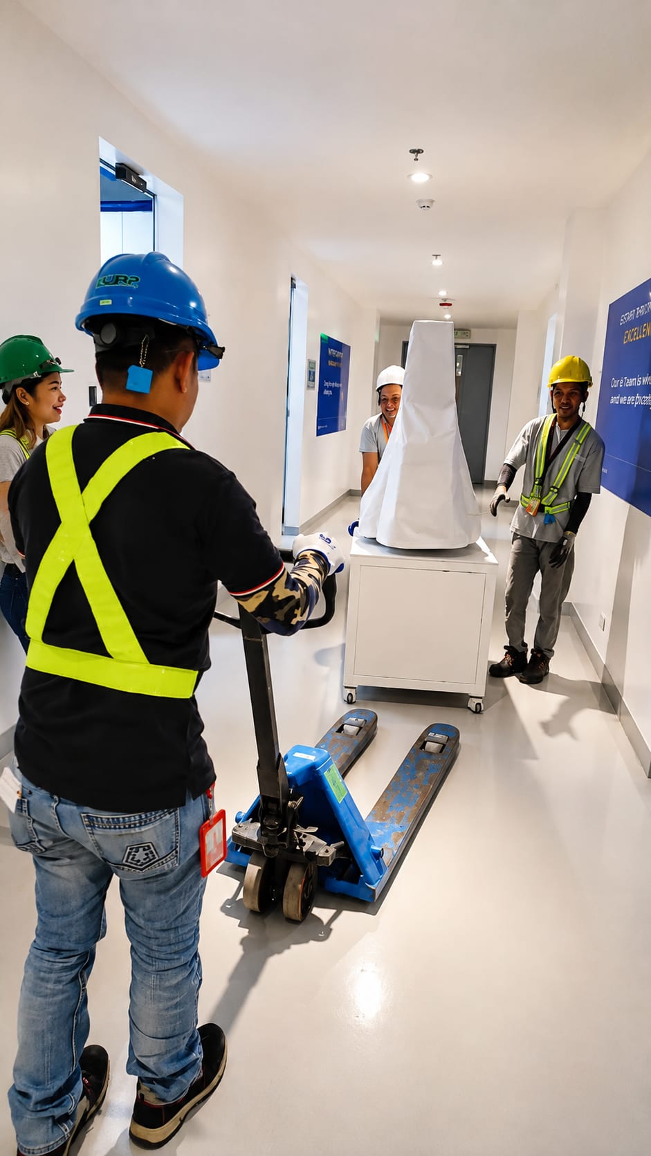 Flex Logistics Inc. crew moving wrapped equipment on a pallet jack indoors
